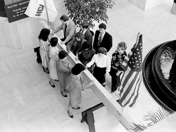 Employees of Hospital Corporation of America autograph a white-painted steel beam in the headquarters lobby