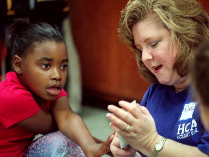 Anitra Green, left, a second-grader at Brookmeade Elementary School, gets assistance from HCA volunteer Becky Raley on telling time Oct. 11, 2002