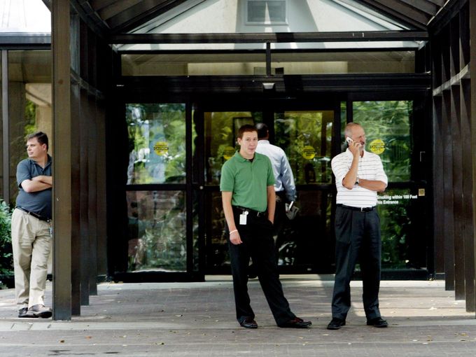 small group of employees wait for the shuttle bus at the front entrance of Building One at HCA on July 24, 2006