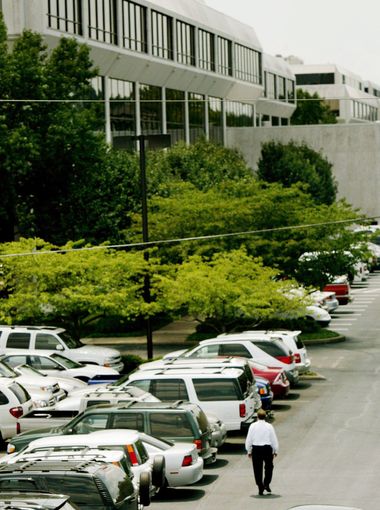 An employee walks in the parking lot next to Building One of HCA on July 24, 2006